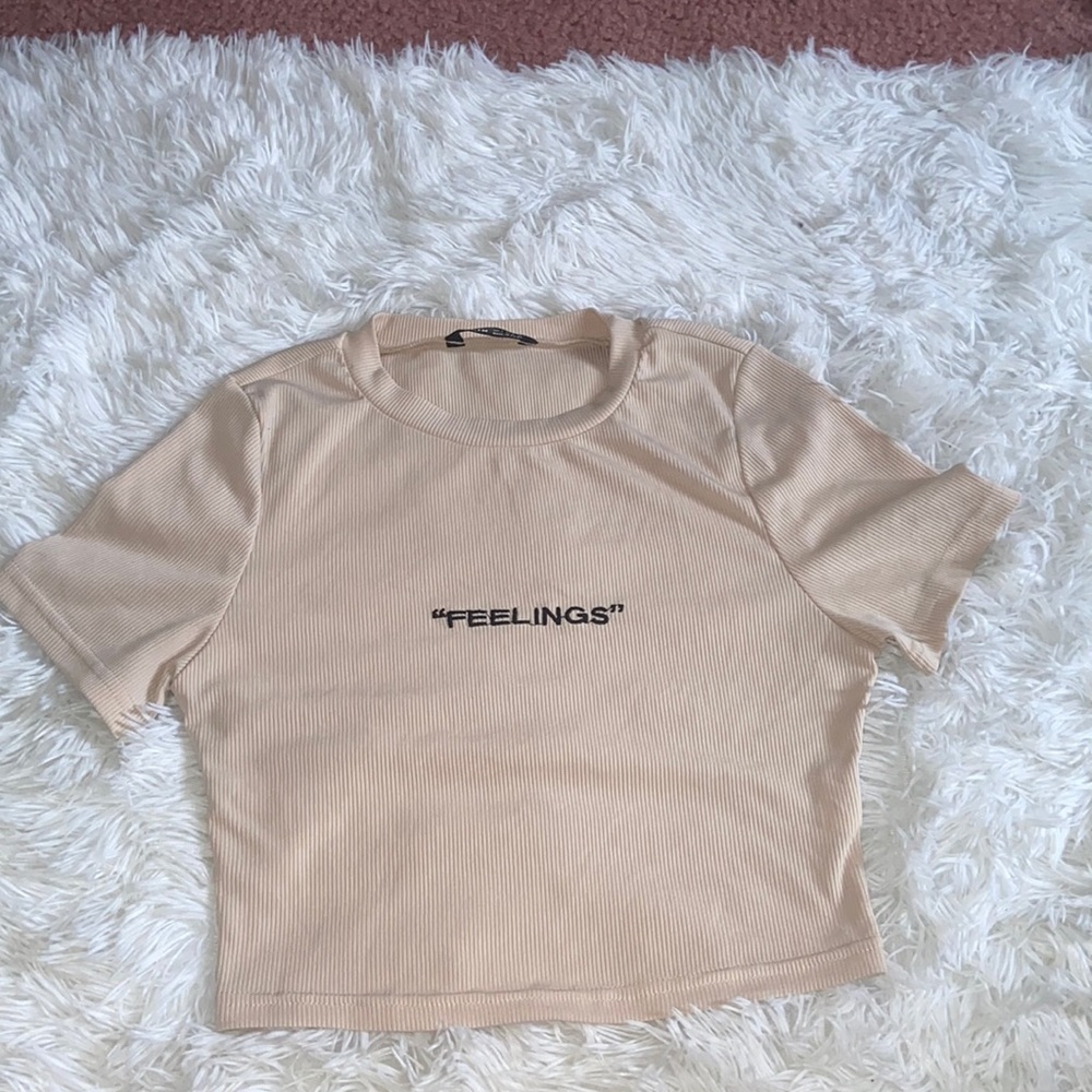 beige cropped “feelings” top